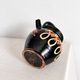 Old vase in glossy black ceramic, vintage exterior decoration.