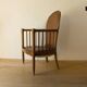 Antique armchair in solid wood and patinated brown leather, early 20th century.