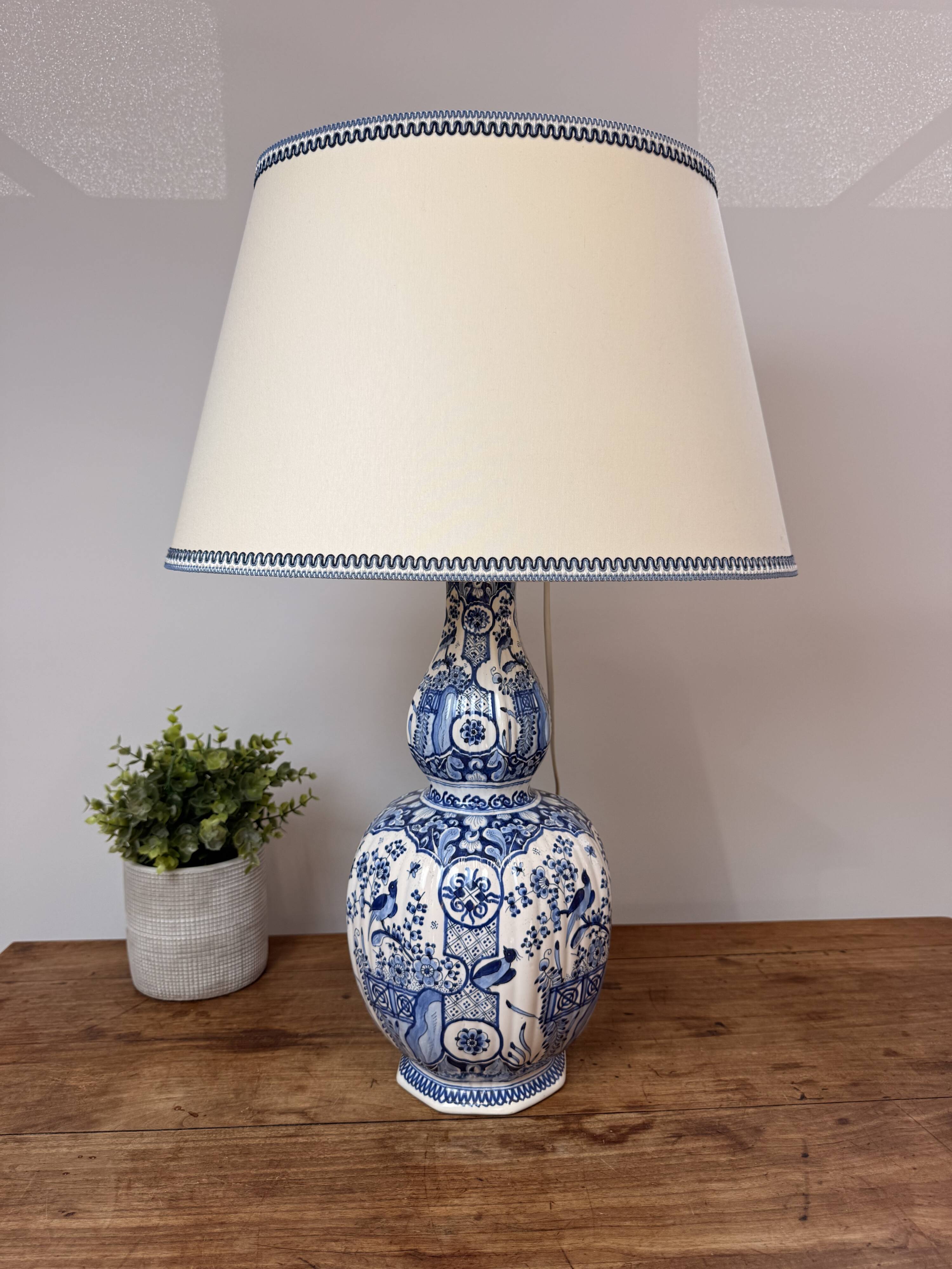 Blue and white Delft ceramic table lamp decorated with birds and flowers.