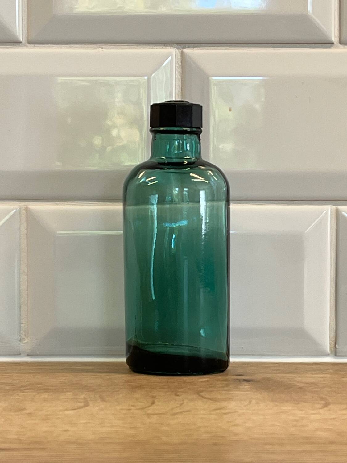 Small vintage dark turquoise blue bottle