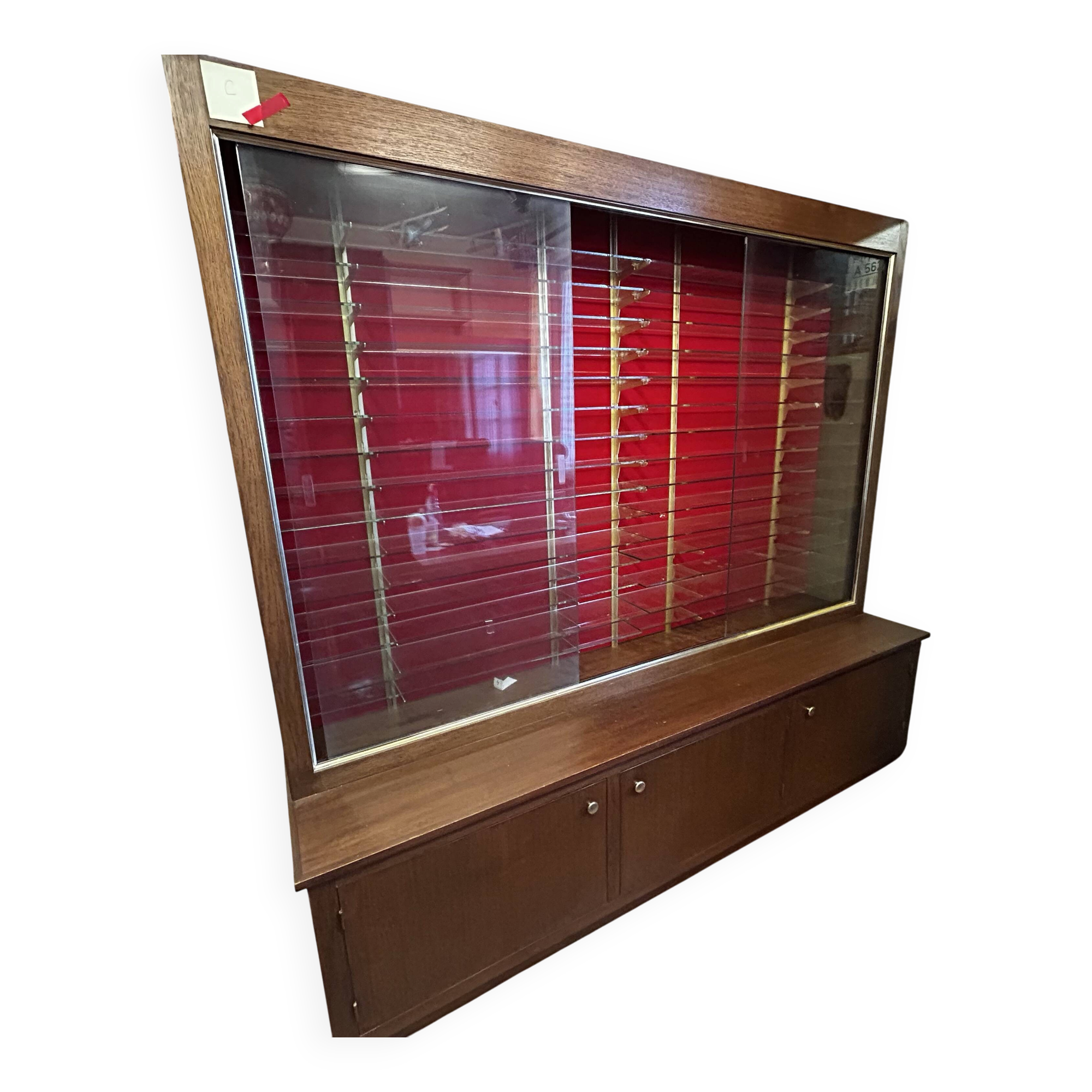 Large vintage display cabinet in wood and glass – red background, 15 shelves