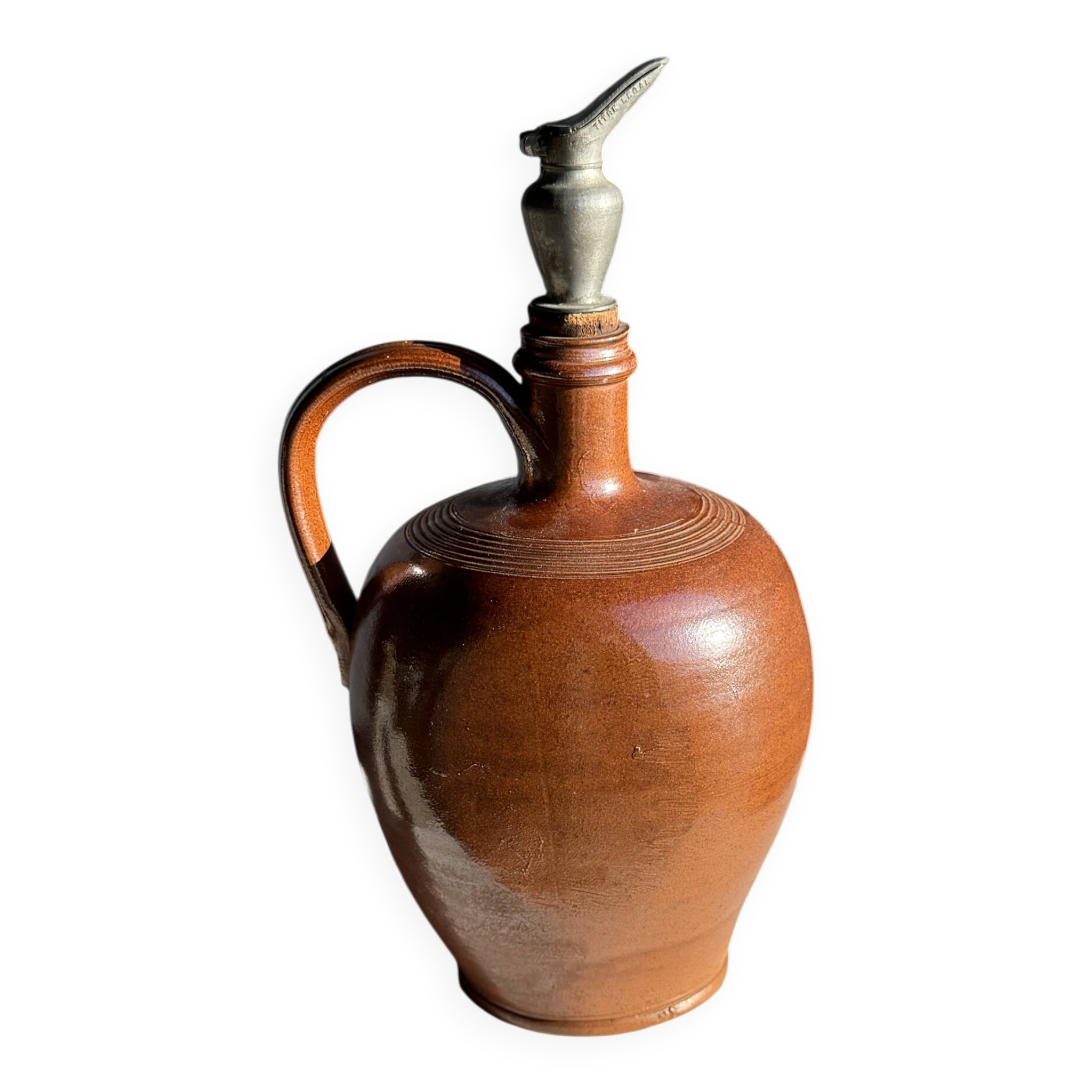 Ancient stoneware jug with a pewter spout.