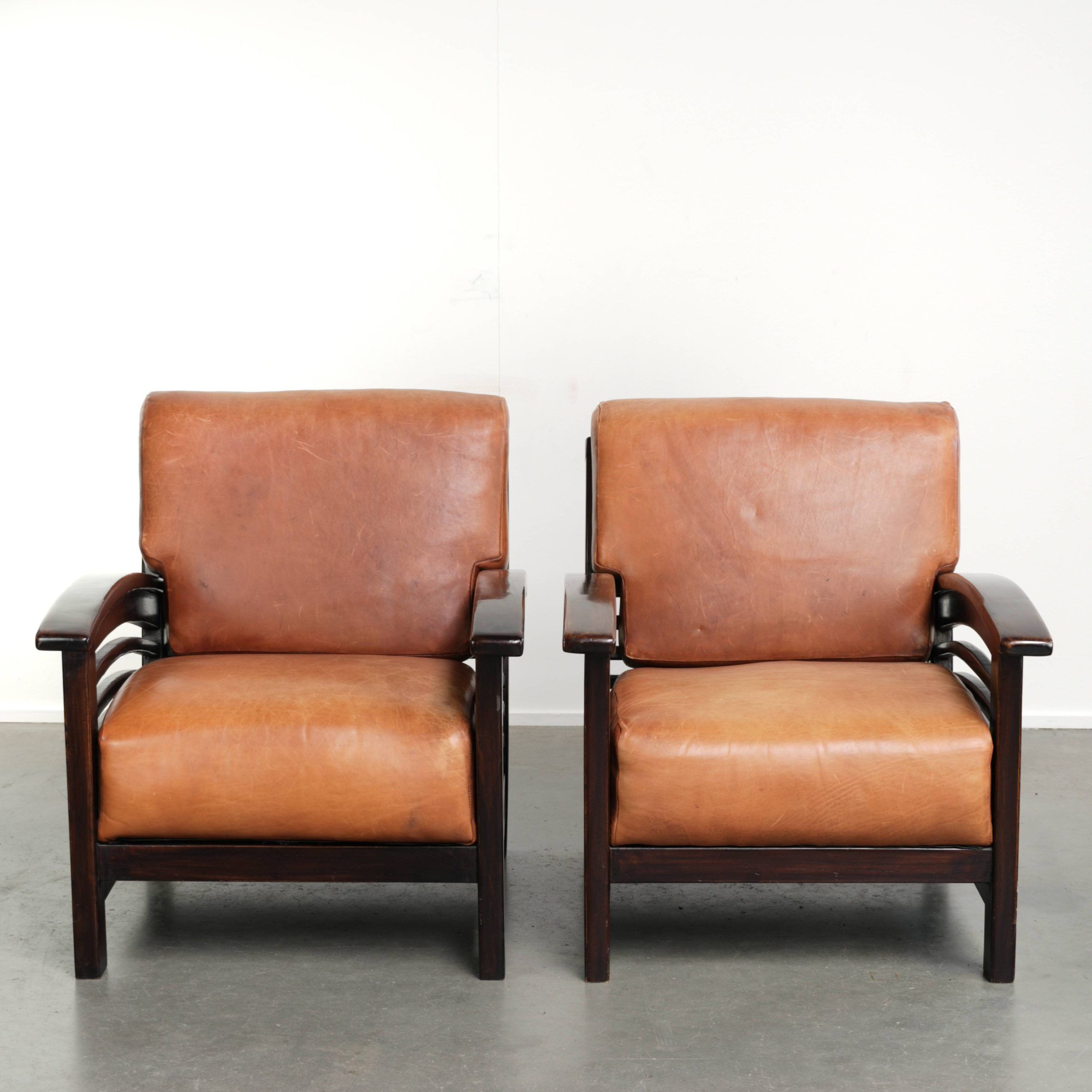Ensemble de 2 fauteuils Art Déco en cuir de vache couleur cognac du 20e siècle.