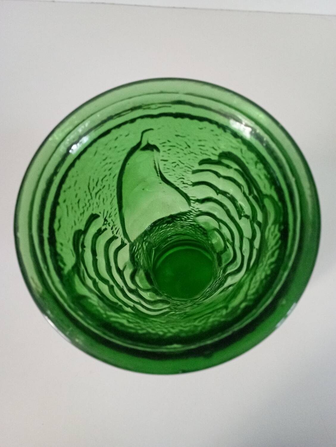 Green glass vase decorated with bunch of grapes and fruits