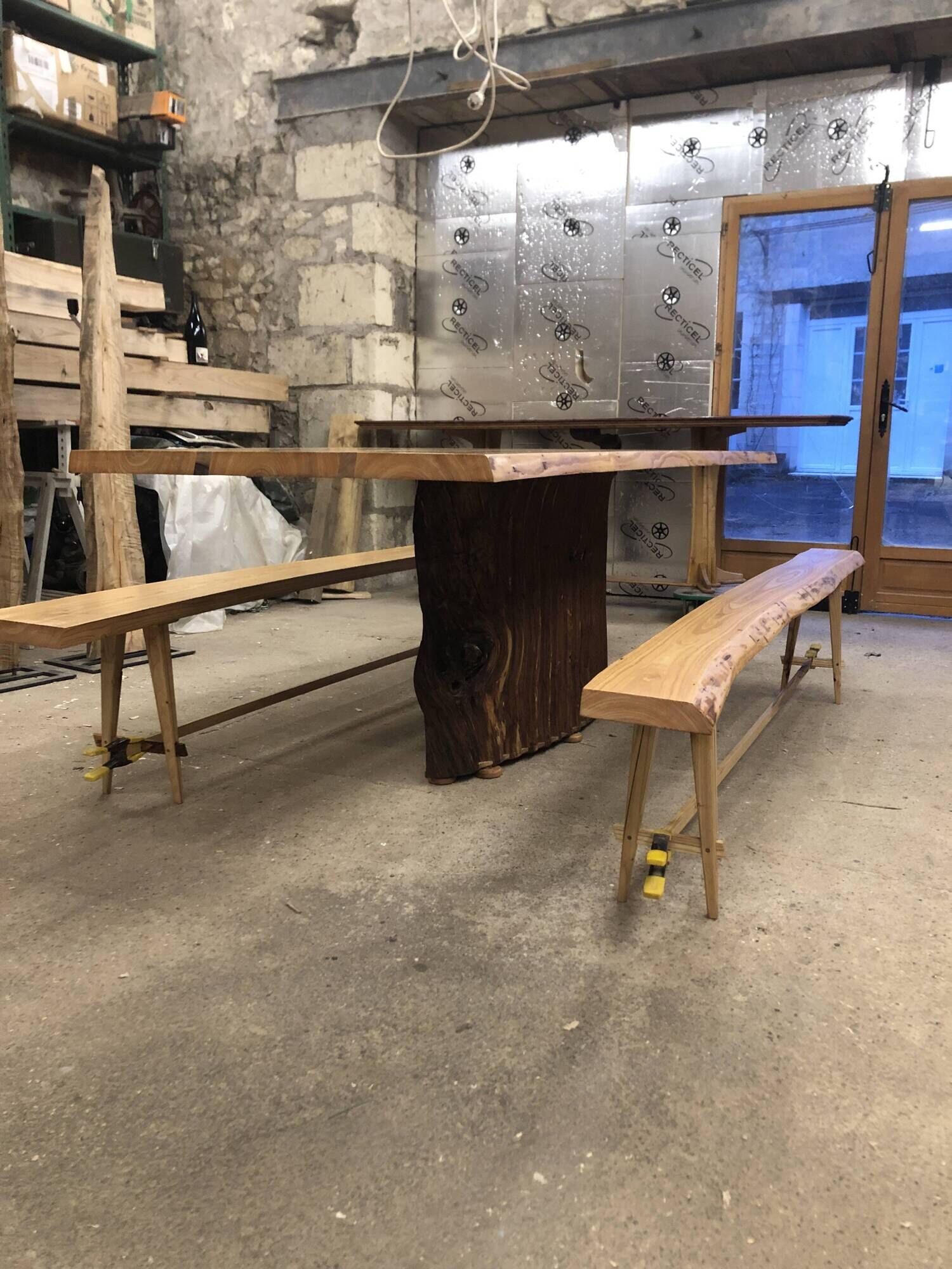 Chestnut and walnut solid table and benches with a central leg.