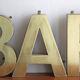 Old brass sign letters, word BAR