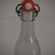 Bottle with mechanical closure in white glass and porcelain stopper.