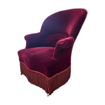 Fauteuil crapaud vintage en velours rouge-bordeaux à franges