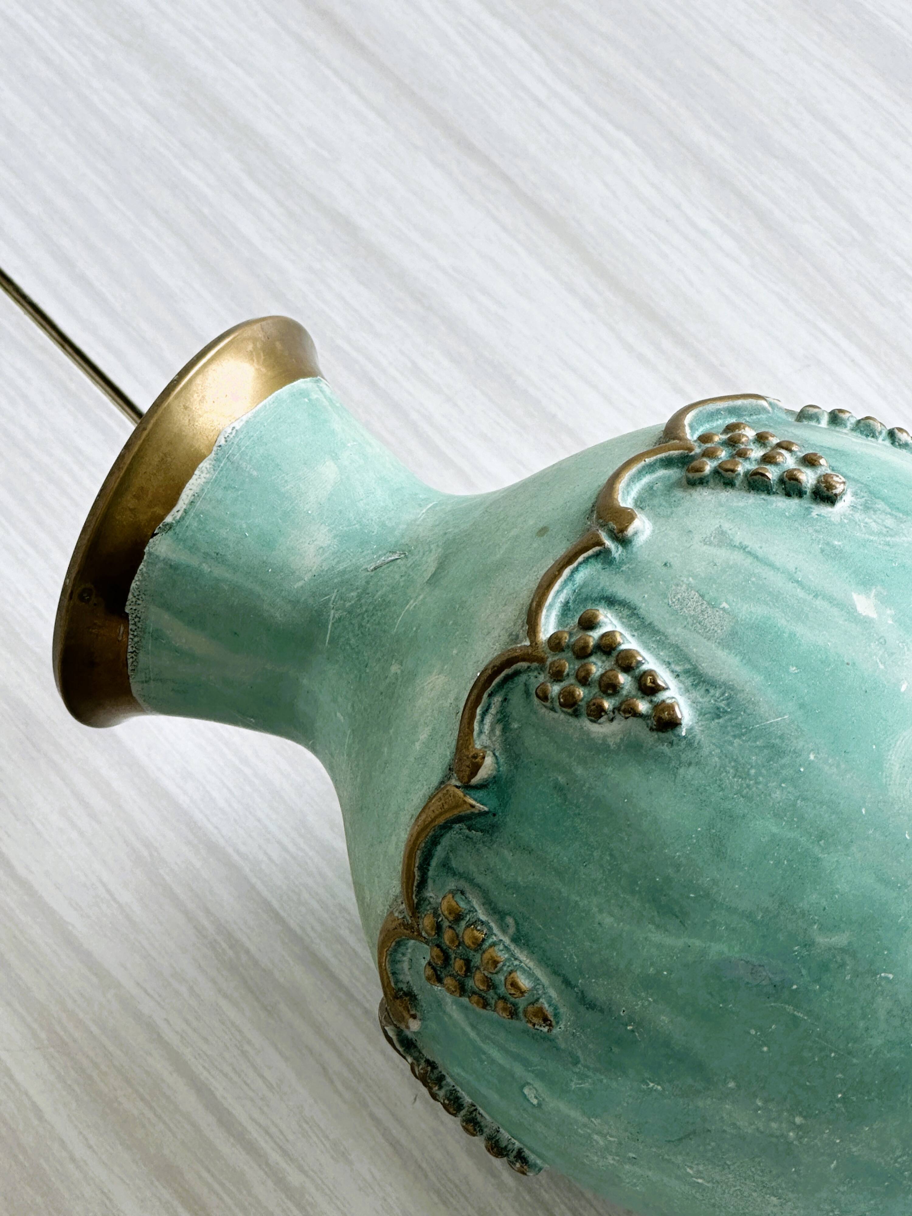 Brass vase decorated with bunches of grapes.
