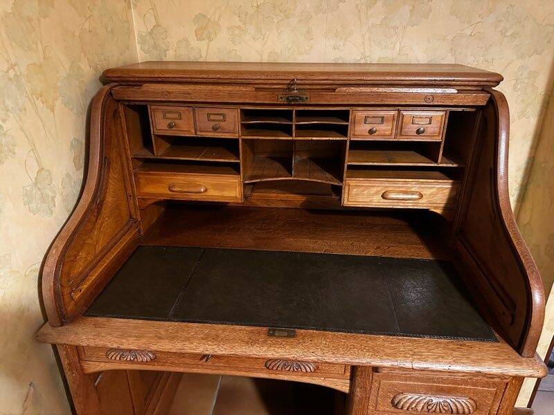 Oak desk with sliding door and leather wood chair.