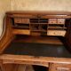 Oak desk with sliding door and leather wood chair.