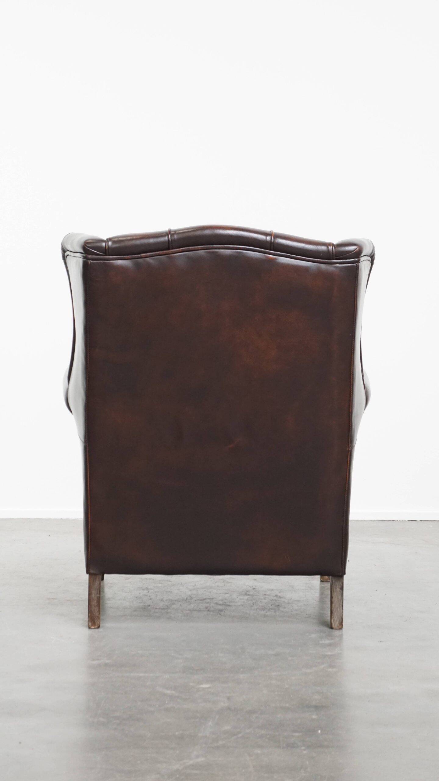 Comfortable wingback chair in English style made of cowhide leather