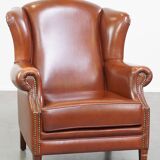 Correct, comfortable, luxurious English-style wingback armchair made of cognac-colored cow leather