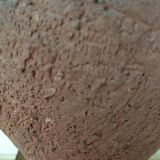 Terracotta vase with gradient of black faded to half on an earth-colored background