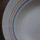 6 old cream-coloured deep plates with blue/orange trim.