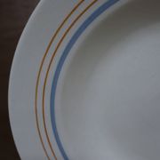 6 old cream-coloured deep plates with blue/orange trim.