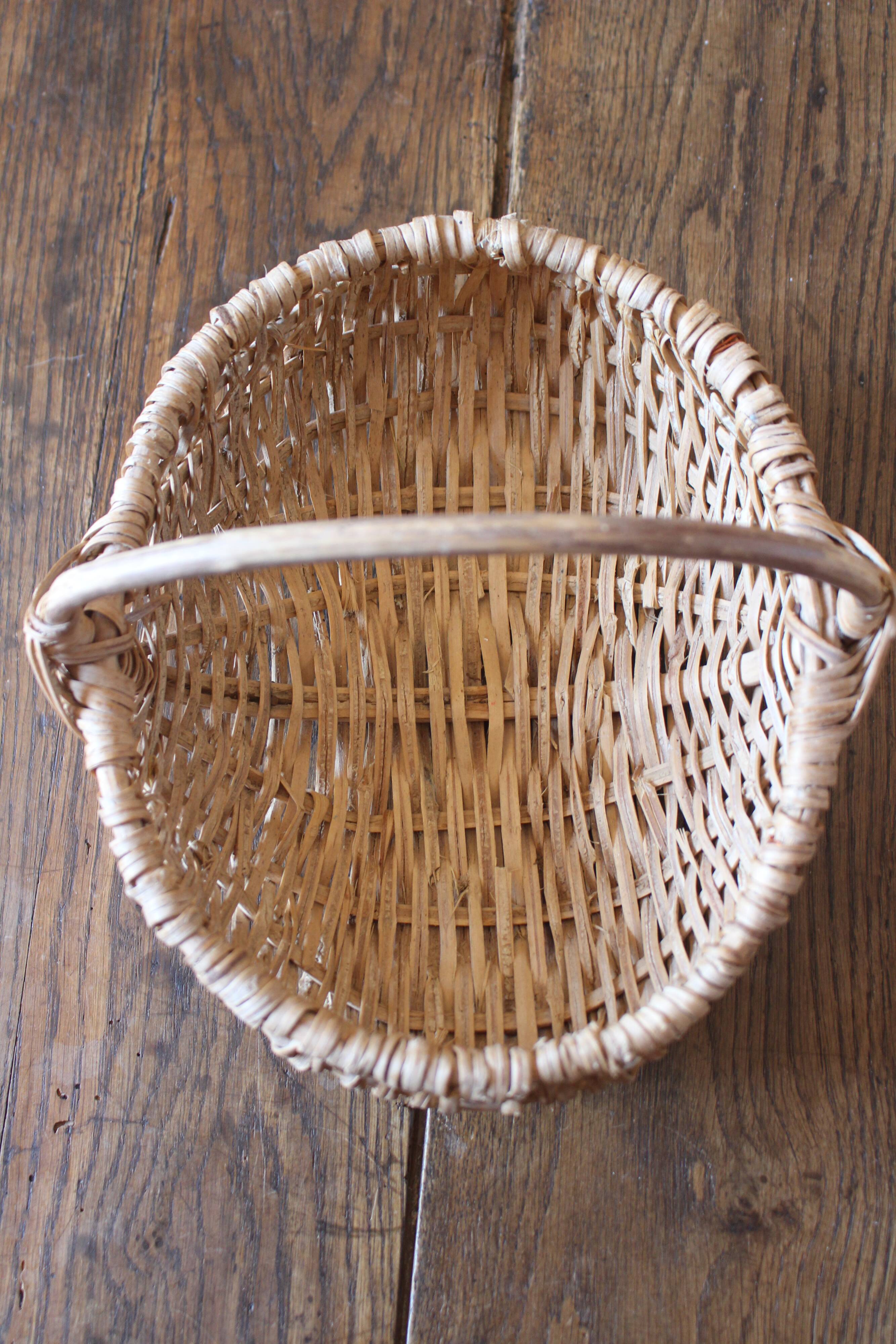 Light wicker oval basket with vintage round handle