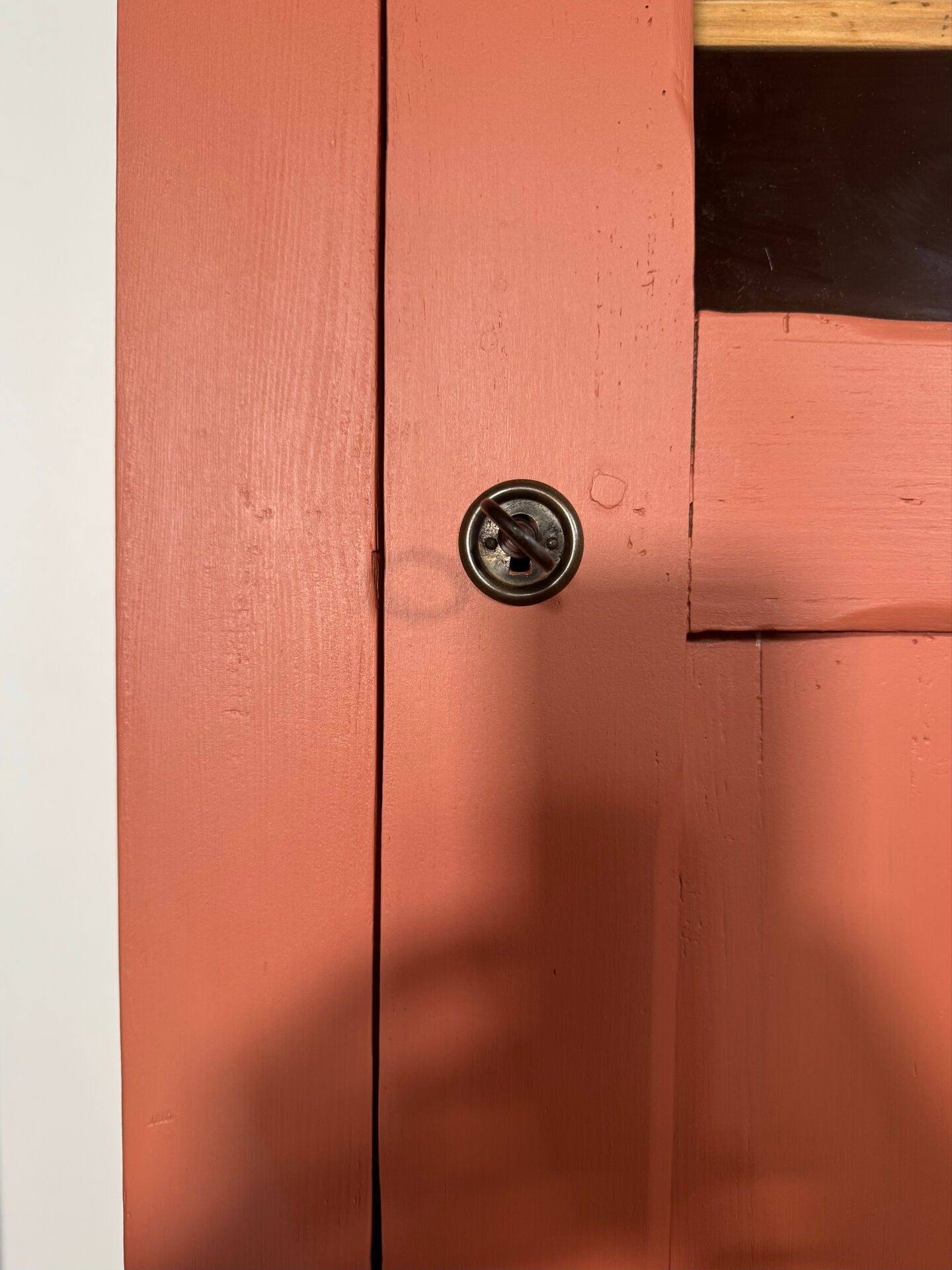 Antique glass-fronted terracotta cupboard