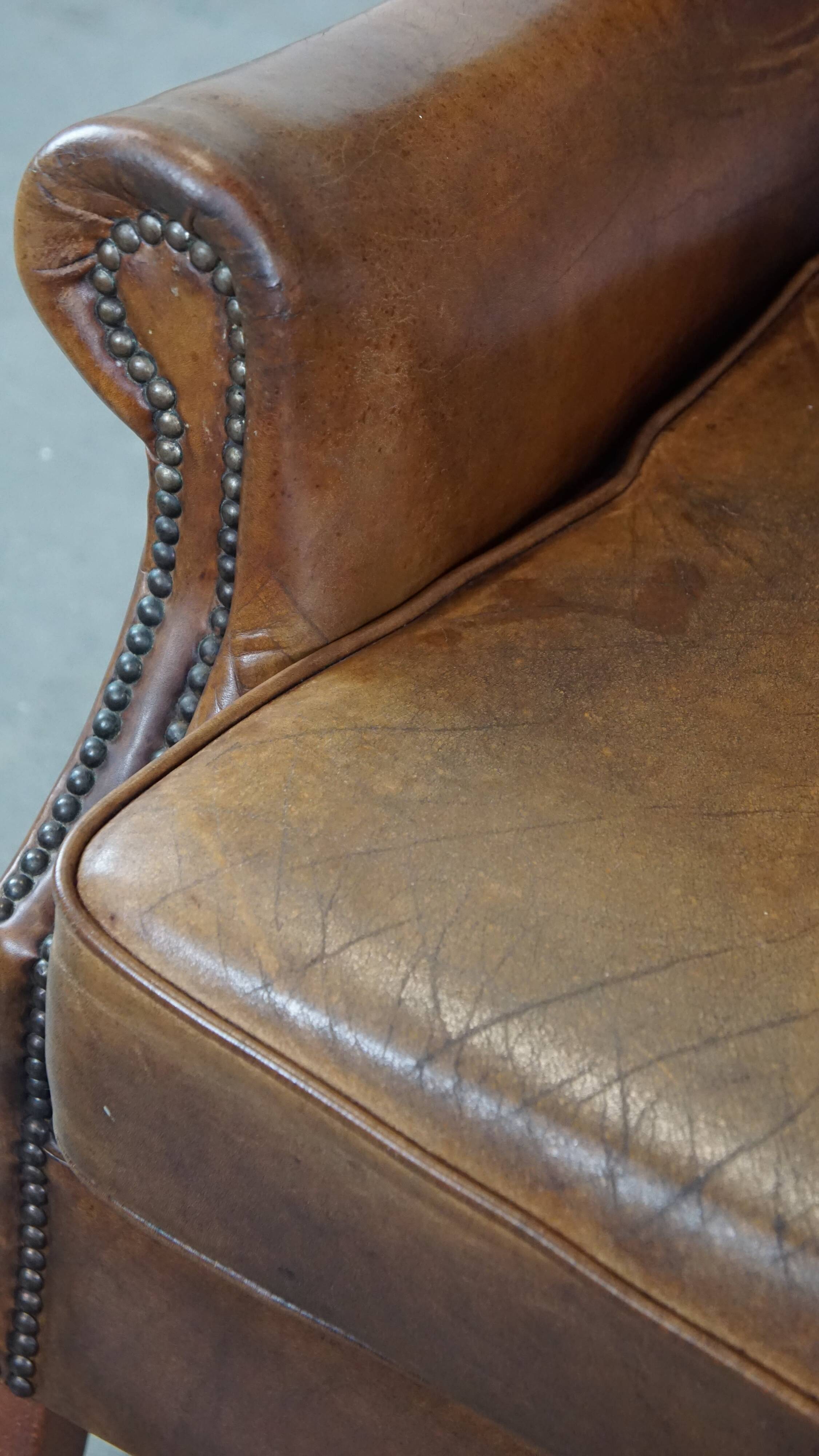 Charming sheep leather wingback armchair with a beautiful patina and excellent seating comfort