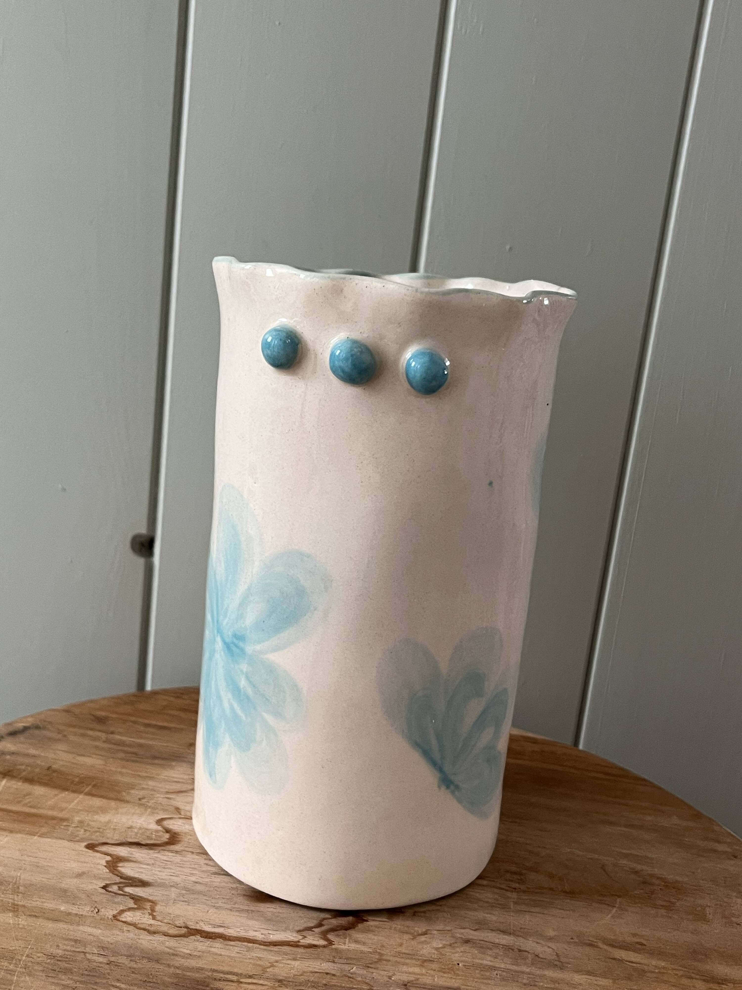 Stoneware vase decorated with flowers in a watercolour style.