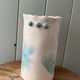 Stoneware vase decorated with flowers in a watercolour style.