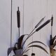 Brass wall lights with a bouquet of reeds by FlorArt.
