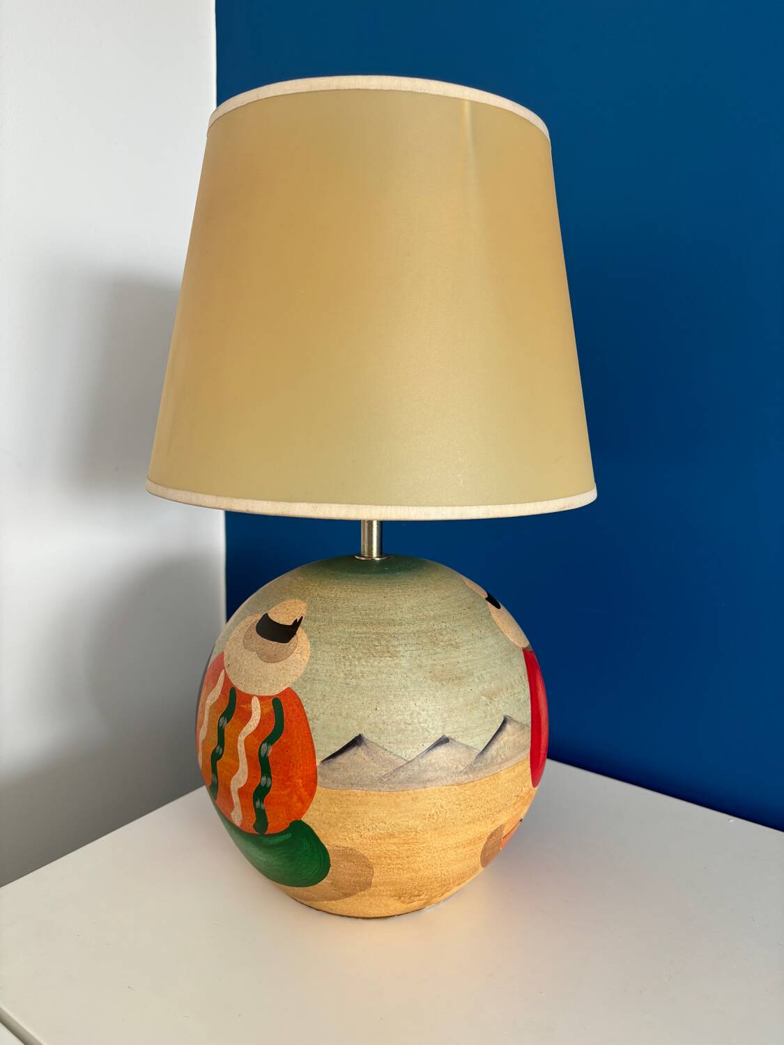 Ceramic table lamp representing women in hats on the sand.