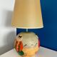 Ceramic table lamp representing women in hats on the sand.