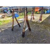 Vintage table with a glass top and smoked plastic trestle legs.