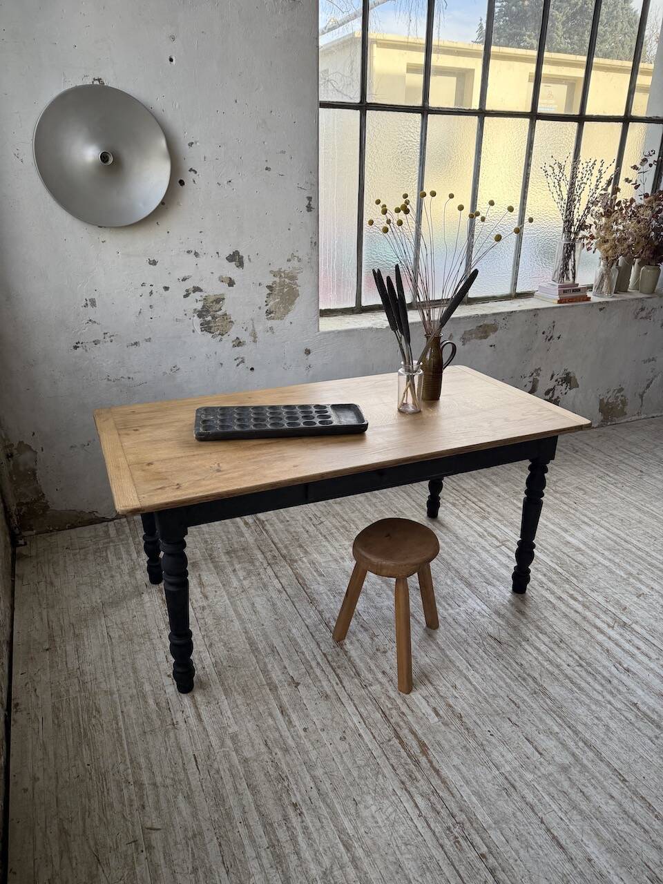 Oak farmhouse table with turned black legs.