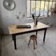 Oak farmhouse table with turned black legs.