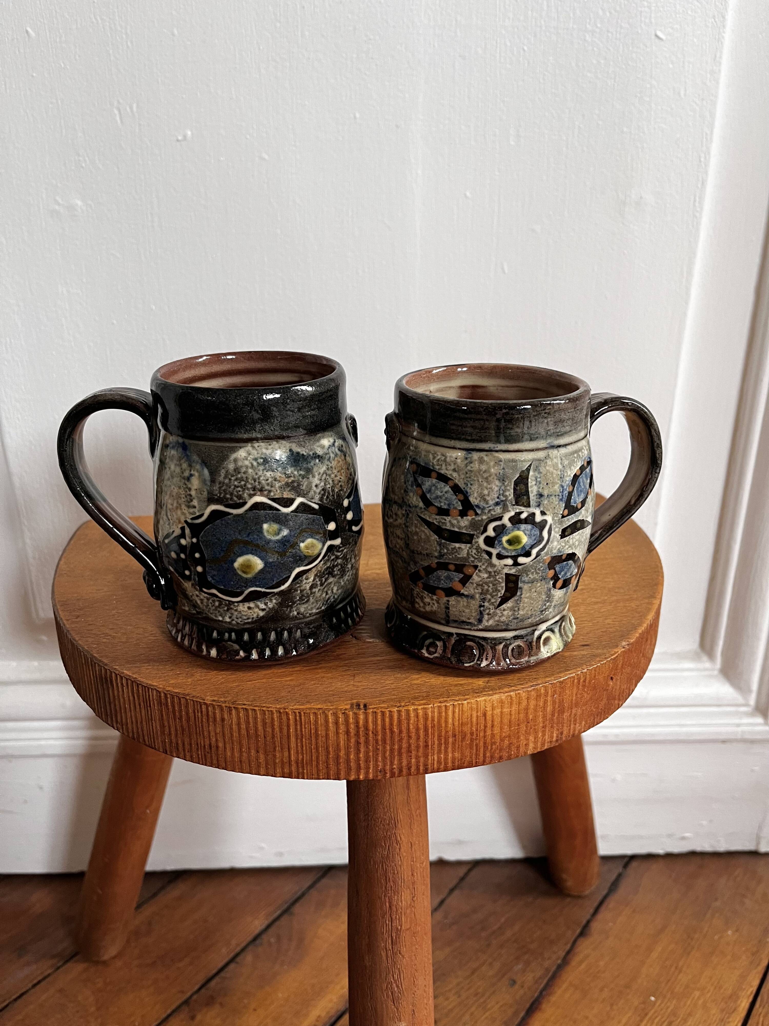Vintage terracotta mugs with glazed designs and flower/fish motifs