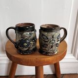 Vintage terracotta mugs with glazed designs and flower/fish motifs