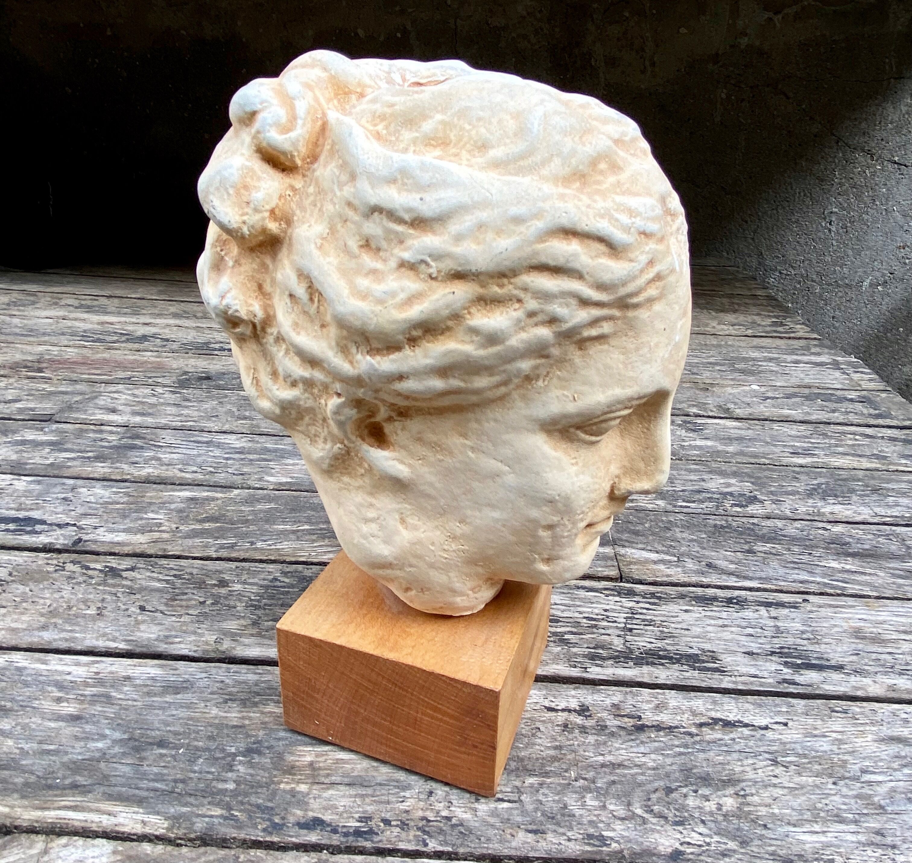 Plaster head of an ancient goddess on its wooden base