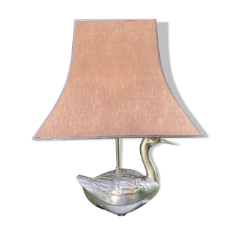 Old vintage lamp representing a duck in silver metal with wooden base