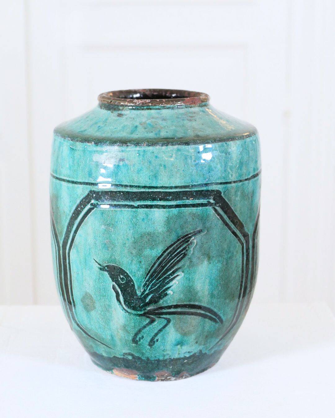 Chinese glazed earthenware vase with bird and flower decoration on a green background