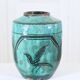 Chinese glazed earthenware vase with bird and flower decoration on a green background