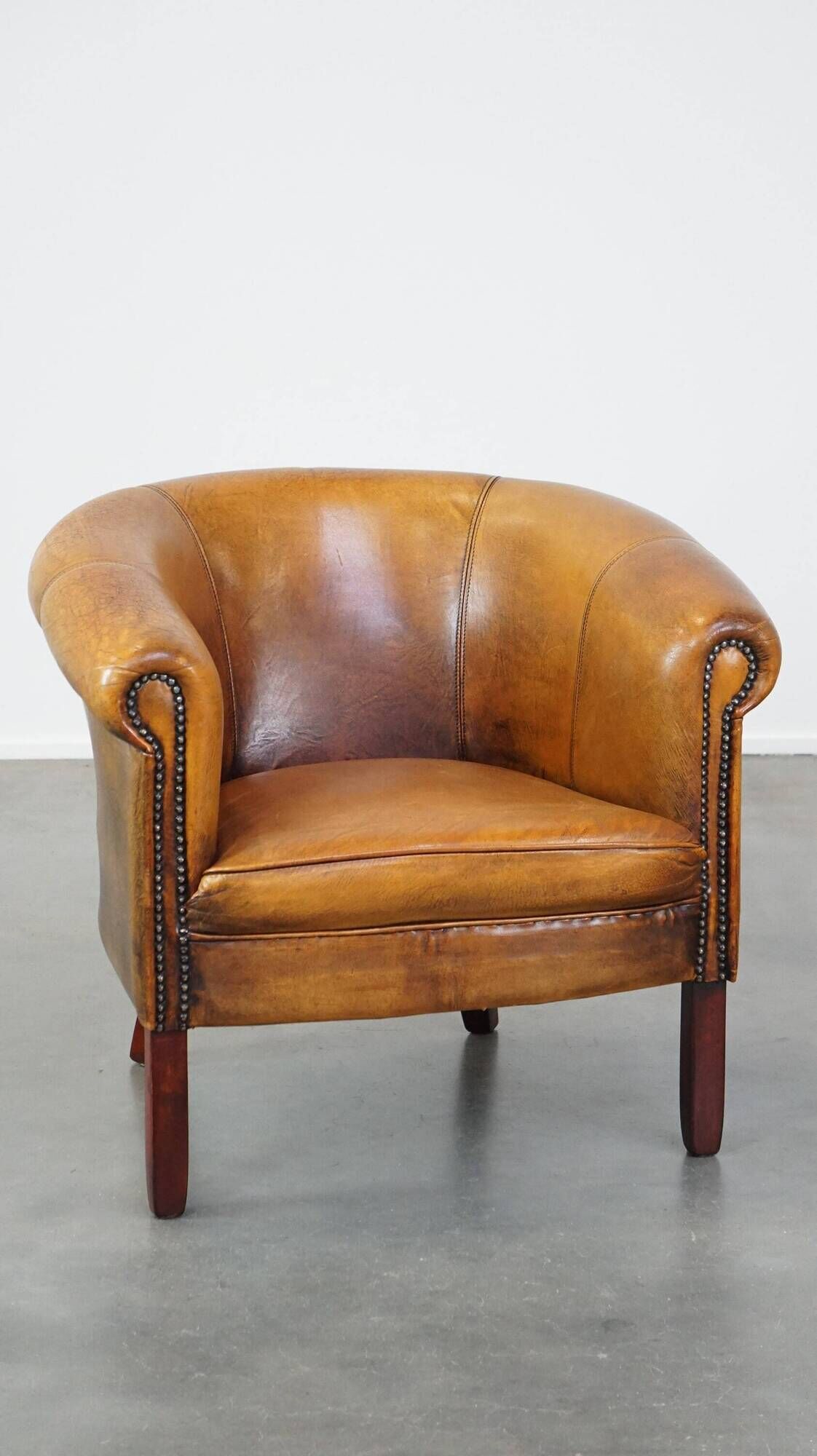 Fauteuil club en peau de mouton subtile avec finition cloutée décorative