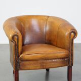 Subtle sheepskin club chair finished with decorative studs