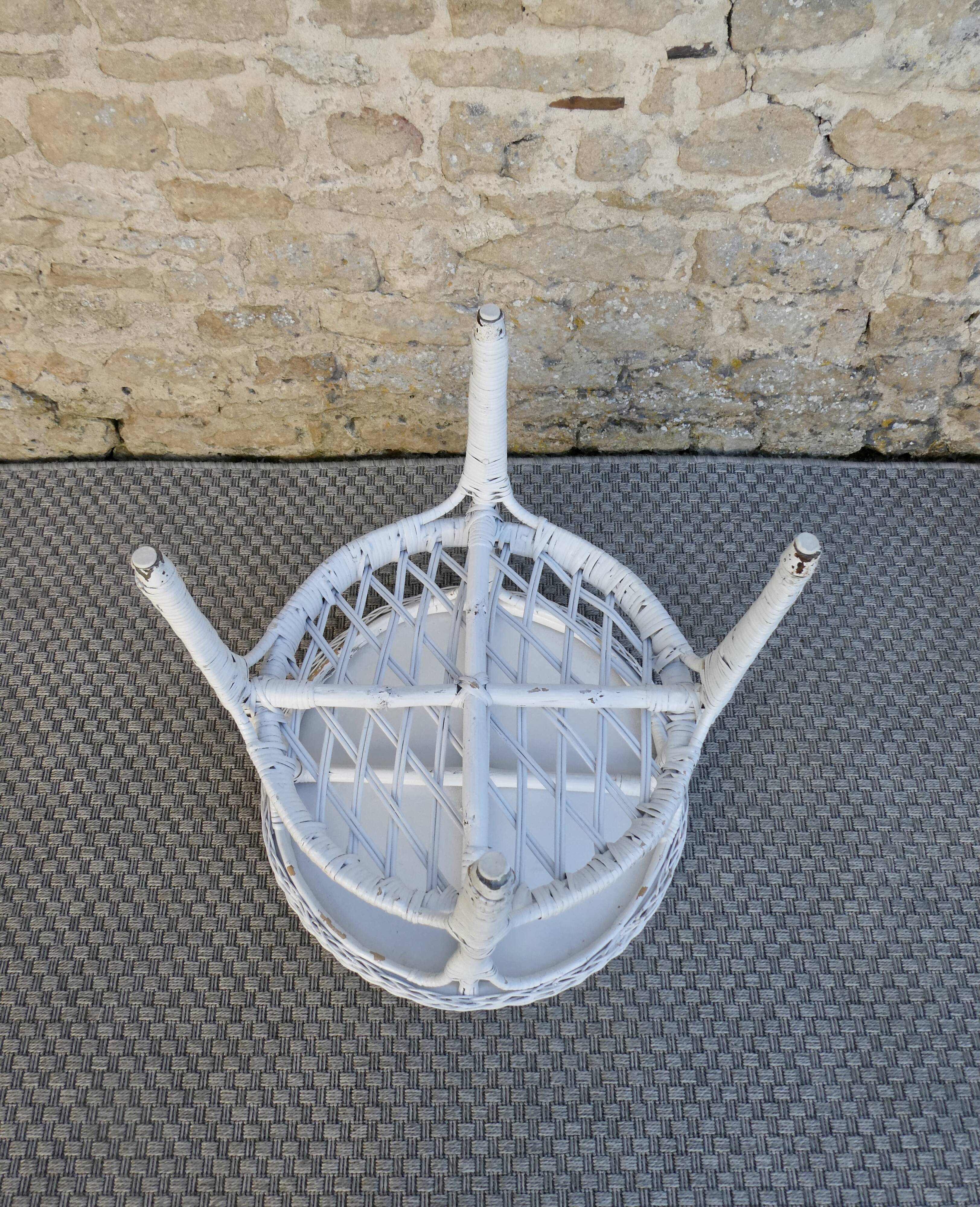 Round white rattan side table with storage underneath, circa 1970.