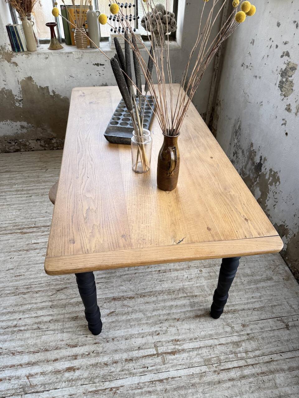 Oak farmhouse table with turned black legs.