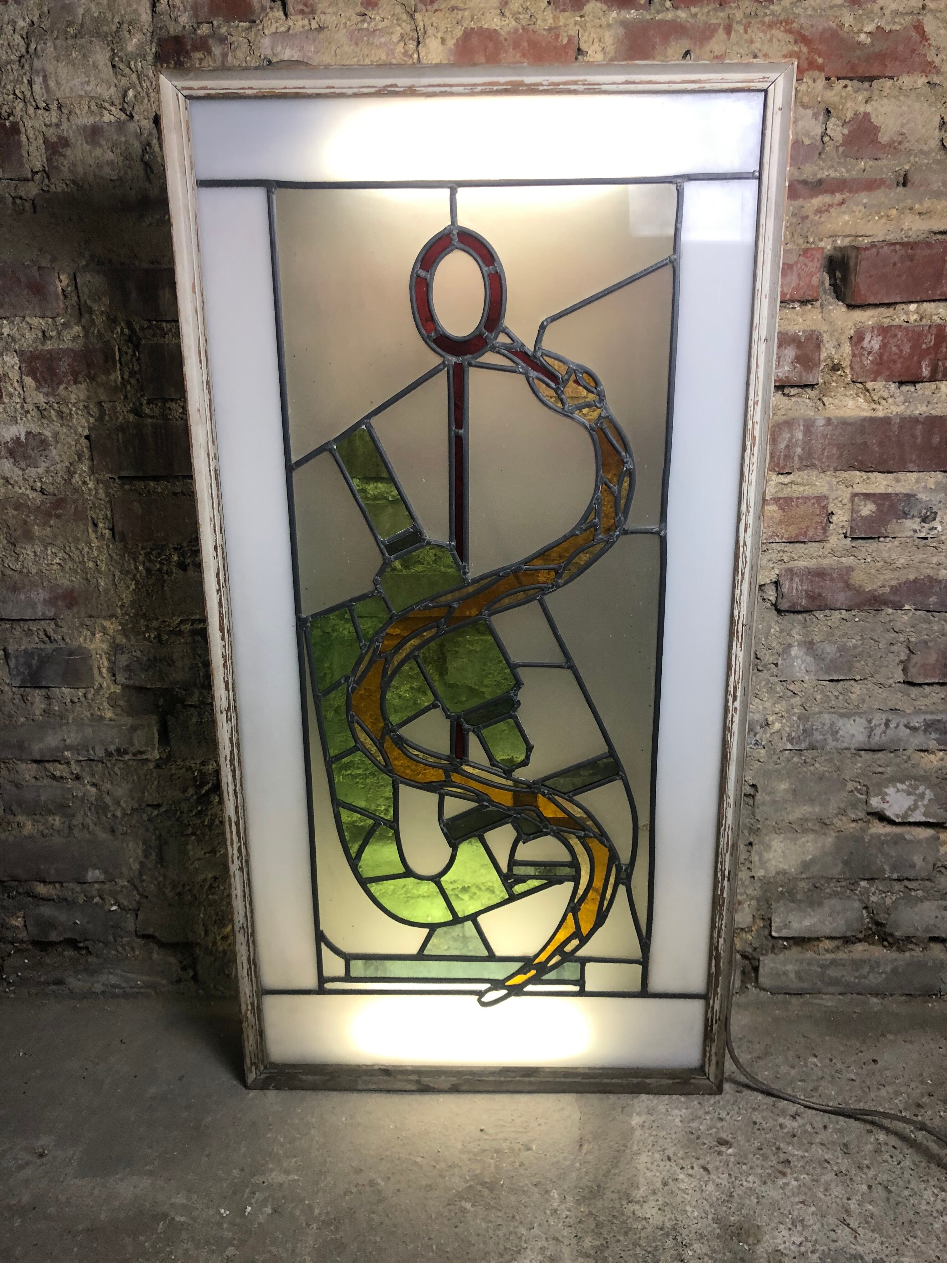 Old stained glass sign with deciduous decoration and microscope