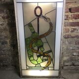 Old stained glass sign with deciduous decoration and microscope