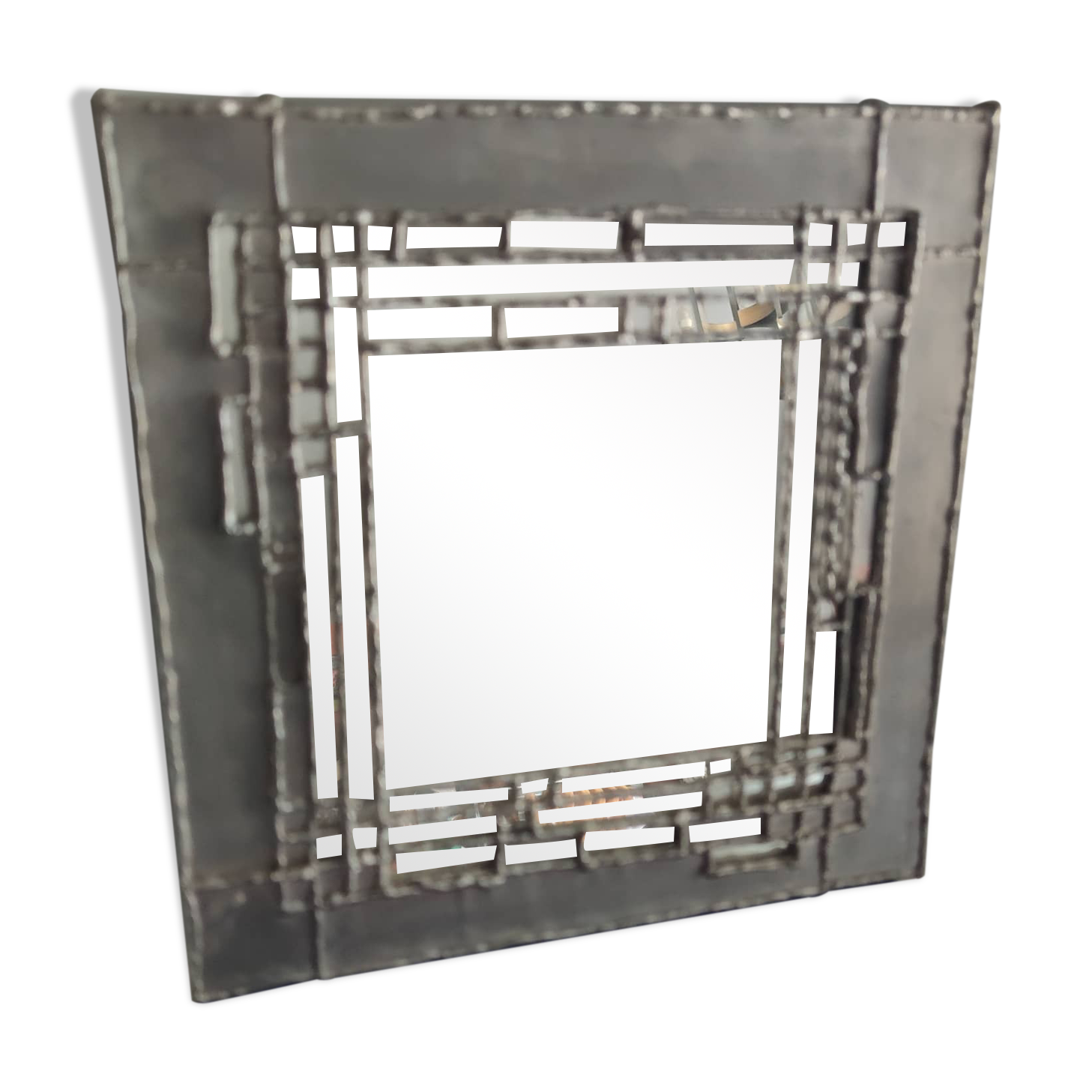 Pewter mirror on a brutalist-style wooden stand