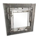 Pewter mirror on a brutalist-style wooden stand