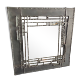 Pewter mirror on a brutalist-style wooden stand