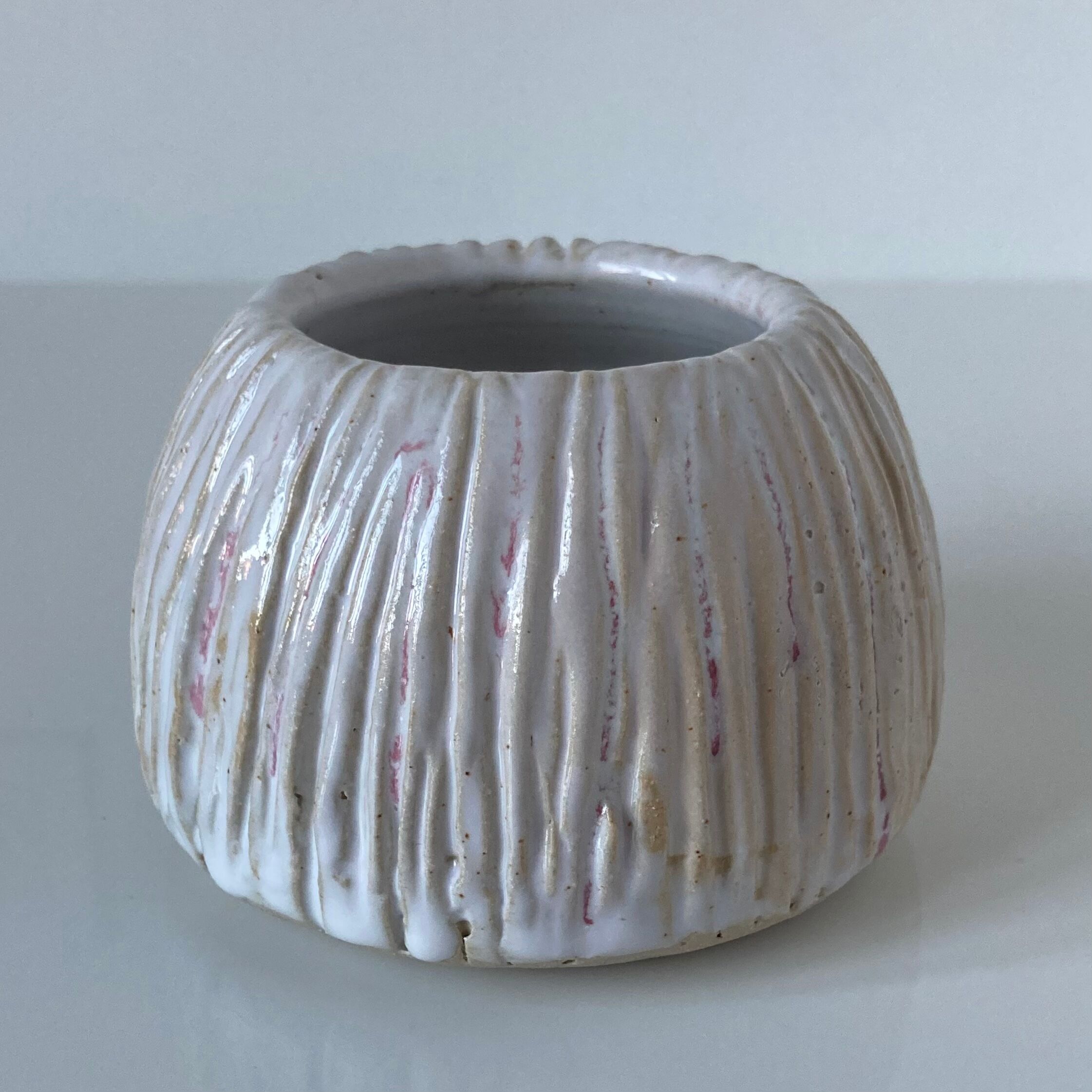 Meeting of three artist's ceramic objects including two pots and a cream covered bowl