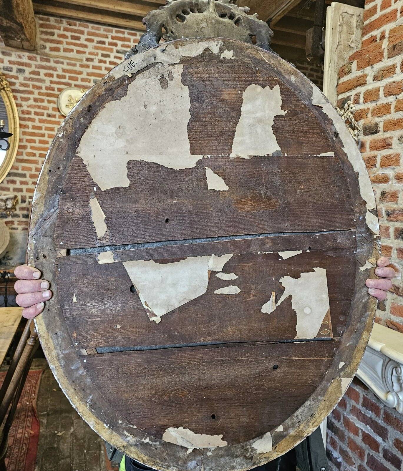 Old black and gold patinated oval mirror louis xv style