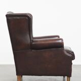 Comfortable wingback chair in English style made of cowhide leather