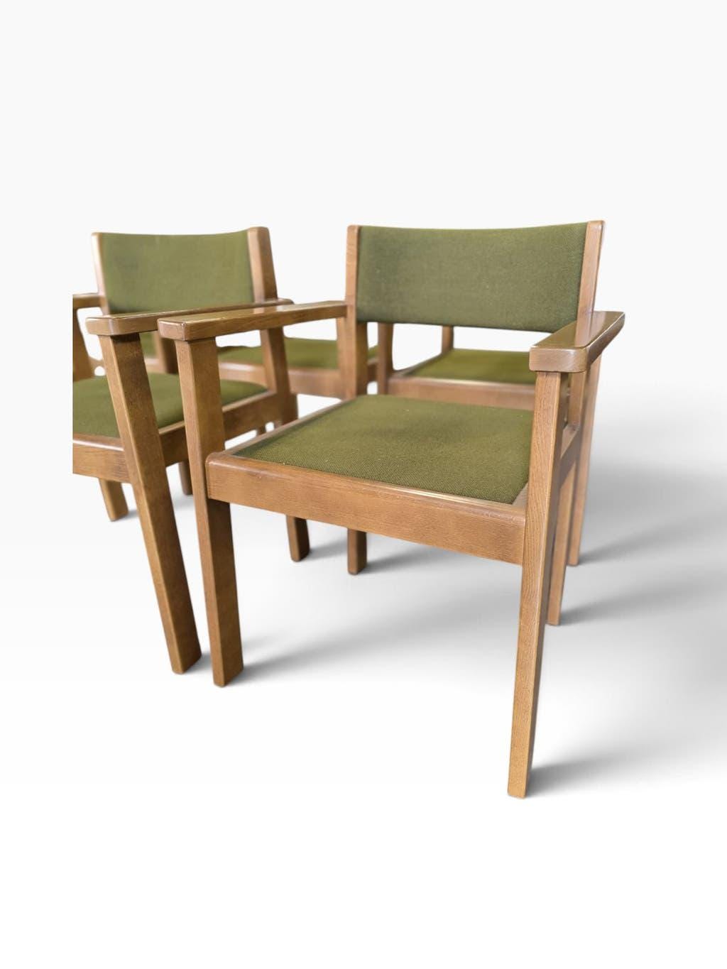 Vintage wooden chair with olive green seat and armrests.